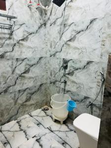 a marble bathroom with a toilet and a sink at Hotel S V Grand in Varanasi