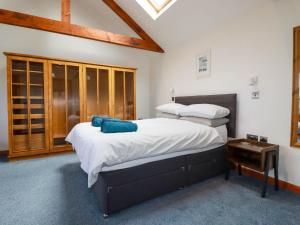 a bedroom with two beds with white sheets and blue pillows at Little Chywoon Barn in Truro