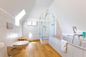 ein Badezimmer mit Toilette und Badewanne in der Unterkunft Fährmann im Häuschen am Rhein in Rees