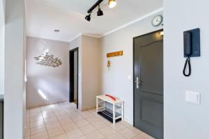 einen Flur mit einer Tür und einem TV an der Wand in der Unterkunft Fährmann im Häuschen am Rhein in Rees