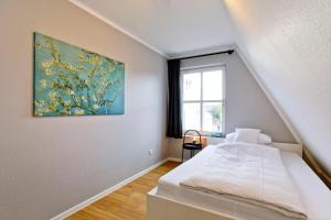 ein Schlafzimmer mit einem Bett und einem Gemälde an der Wand in der Unterkunft Fährmann im Häuschen am Rhein in Rees + 3 Fotos