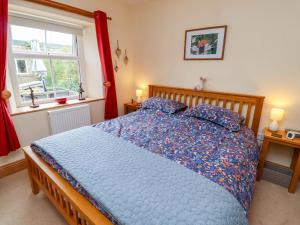 une chambre avec un lit avec une couette bleue et une fenêtre dans l'établissement Folly View, à Alnwick