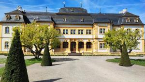 a large yellow house with trees in front of it at Monteur-Ferienwohnung mit 123qm bei Würzburg mit Parkplatz Terasse Grill WLAN in Veitshöchheim