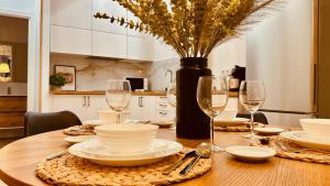 einem Holztisch mit Tellern, Gläsern und einer Vase in der Unterkunft Click&Guest - Modern and Luxury Flat in Telde in Salinetas + 33 Fotos