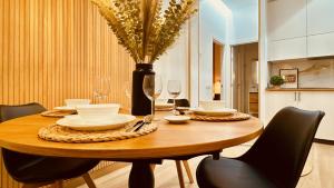 einen Esstisch mit Stühlen und eine Vase mit Blumen in der Unterkunft Click&Guest - Modern and Luxury Flat in Telde in Salinetas