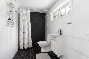 une salle de bain blanche avec toilettes et lavabo dans l'établissement Dream cottage in the Stockholm archipelago, à Djurhamn 50 autres photos