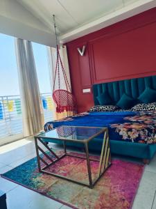 Schlafzimmer mit einem blauen Bett und einem Glastisch in der Unterkunft Parimahal Cottage in Shimla