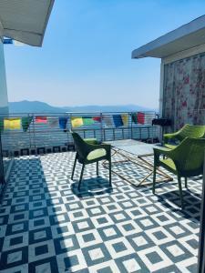 ein Balkon mit Stühlen und Blick auf das Meer in der Unterkunft Parimahal Cottage in Shimla