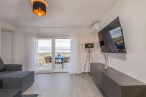a living room with a couch and a television at Restaurant & Rooms Nino in Porat