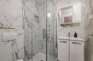 a white bathroom with a shower and a sink at Restaurant & Rooms Nino in Porat +41 photos