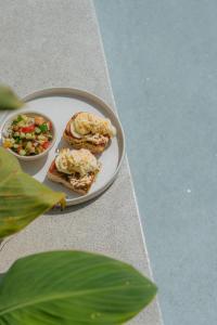 a plate with sandwiches and a bowl of salad at Global Surf Lodge Kabalana in Ahangama