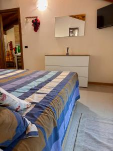 Un dormitorio con una cama con una manta azul y blanca. en appartamento antonella, en Brentonico 5 fotos más