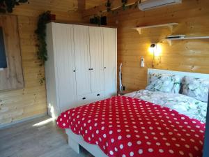 a bedroom with a bed with a red polka dot blanket at Mecsekalja Fakuckó in Pécs