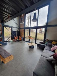 Banský StudenecにあるIRON LODGE Banský Studenecのソファとテーブルと窓のあるリビングルーム