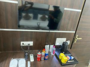 a table in a hotel room with drinks and a tv at Taj Comfort Inn in Agra