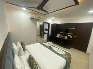 a bedroom with a large white bed in a room at Taj Comfort Inn in Agra +4 photos