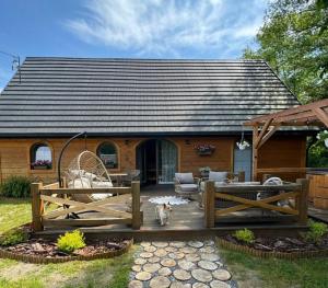a dog sitting on a patio in front of a house at Chlewiska nad Świnką in Narol