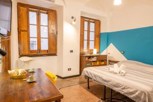 Zimmer mit einem Bett und einem Holztisch in der Unterkunft Lovingenoa - Ducale - Old Stone in Genua
