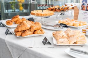 a table with plates of croissants and pastries at Mercure Olbia Hotel e Spa in Olbia