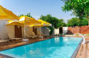 a swimming pool with two yellow umbrellas and a pool at Collesium Garden in Antalya