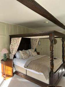 a bedroom with a bed with a canopy at Ravenwood Hall Hotel in Bury Saint Edmunds