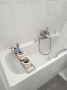 a white bath tub with a shower in a bathroom at Eismauer Suite in Rüdesheim am Rhein