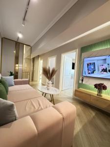 a living room with two beds and a flat screen tv at Luxury Evergreen Towers by Glam Apartments in Iaşi