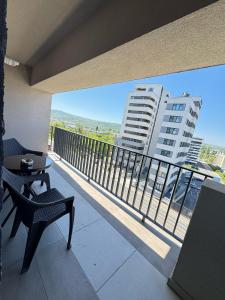 a balcony with a table and chairs and a view of a building at Luxury Evergreen Towers by Glam Apartments in Iaşi +60 photos
