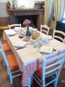サッロクにあるAgriturismo Santa Barbaraの白いテーブルクロスと青い花瓶が置かれたテーブル