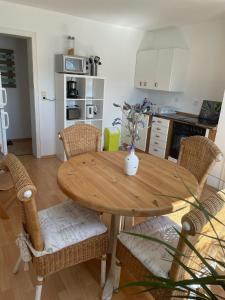 ein Holztisch in einer Küche mit Stühlen und einer Tisch- und Stuhlplatte in der Unterkunft Ferienwohnung in Adenau am Nürburgring in Adenau