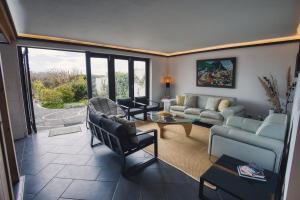 una sala de estar con un sofá y una mesa en Azores Awaits, en Ribeira das Tainhas