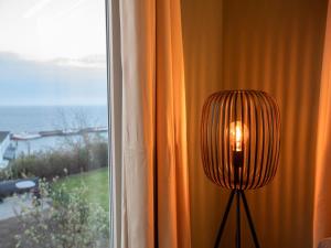 a lamp sitting next to a window with a view at Haus Waterkant - traumhafter Meerblick und Garten in Sassnitz