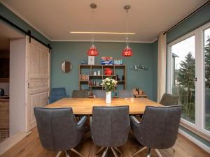 a dining room with a wooden table and chairs at Haus Waterkant - traumhafter Meerblick und Garten in Sassnitz +33 photos