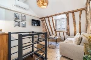 salon ze schodami i kanapą w obiekcie Ultra Central Historical Parisian Flat - Louvre w Paryżu