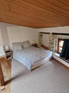 a bedroom with a bed and a wooden ceiling at Spacious village house completely renovated in Pennautier