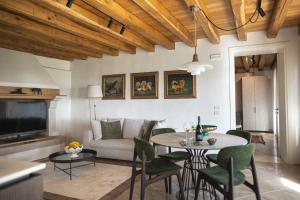 a living room with a table and chairs and a couch at Tenuta Duchi Corbanus in Corbanese
