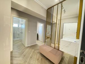 a living room with a large mirror and a bench at Love My Apartments Near Airport - Underground Parking in Iaşi +102 photos