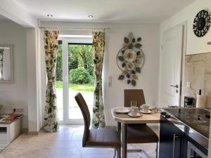 a kitchen with a table and chairs and a window at Romantic Greenhouse in Syke