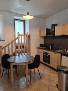 a kitchen with a table and chairs in a room at Studio AL'escapade in Saint-Chély-dʼApcher