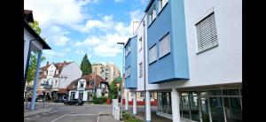 Wunderschöne und zentrumsnahe Ferienwohnung 75 qm في فريبورغ ام بريسغاو: شارع المدينة مبنى ازرق وابيض