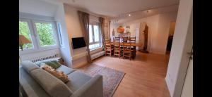 Wunderschöne und zentrumsnahe Ferienwohnung 75 qm في فريبورغ ام بريسغاو: غرفة معيشة مع أريكة وغرفة طعام