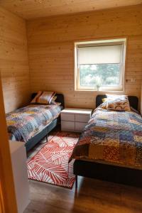 two beds in a room with a window at Willa Aleksandria in Grabie