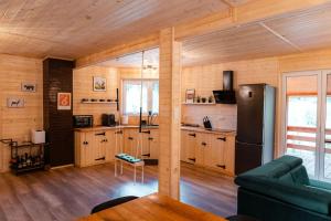 a kitchen with wooden cabinets and a refrigerator at Willa Aleksandria in Grabie