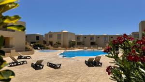 a swimming pool with lounge chairs and a resort at SUN & SURF Tejita in El Médano