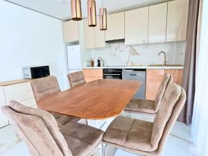a kitchen with a wooden table and chairs at Luxury Apartments in Balatonalmádi I Almádi Lux Apartman IV - Velvet Oak in Balatonalmádi