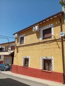 a yellow and red building on the side of a street at Tío Abraham in El Raso