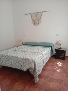 a bedroom with a bed with a green and white blanket at Tío Abraham in El Raso