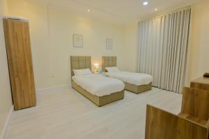a hotel room with two beds in a room at RJ's - Beautiful 3 Bedroom Apartment in Al Khobar