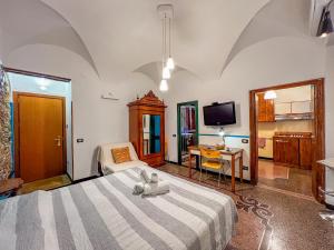 ein Schlafzimmer mit einem Bett, einem Schreibtisch und einem Fernseher in der Unterkunft Lovingenoa - Ducale - Old Stone in Genua