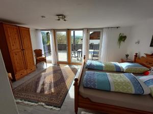 a bedroom with two beds and a balcony at AnNo - Wohlfühlplatzal in da Mauth in Mauth